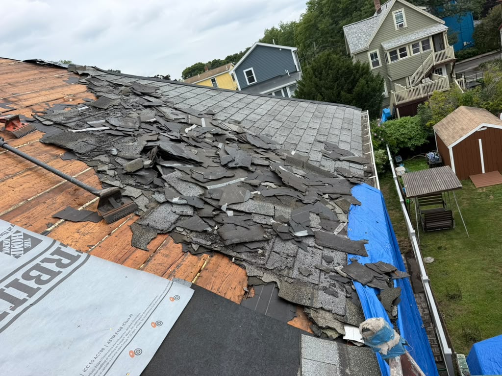 Exposed roof decking during a roof replacement project by Ronie Construction in Massachusetts