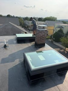 Skylights installed on a flat roof during a Ronie Construction roofing project in Massachusetts
