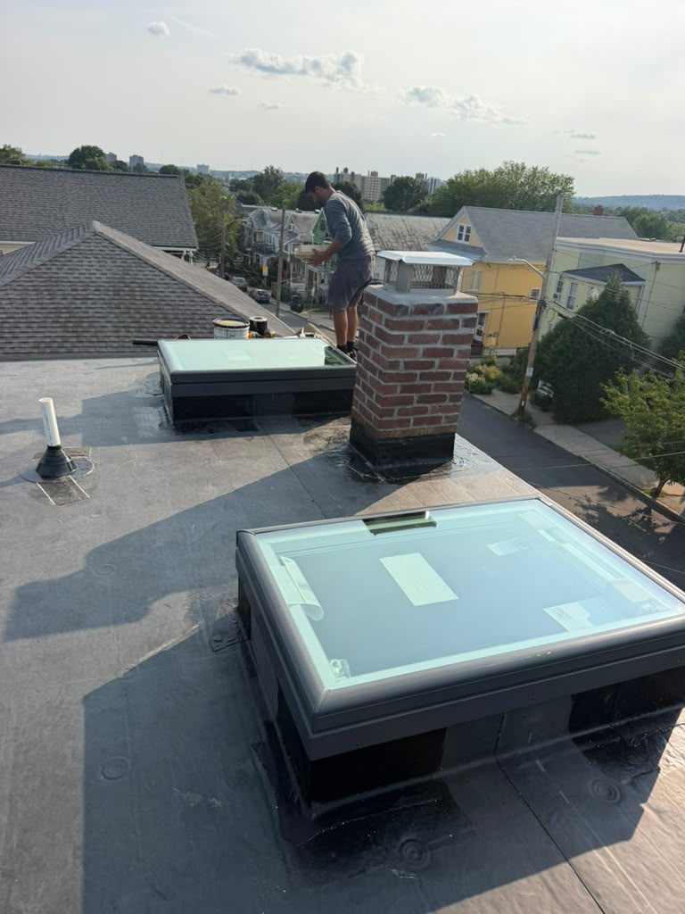 Skylights installed on a flat roof during a Ronie Construction roofing project in Massachusetts