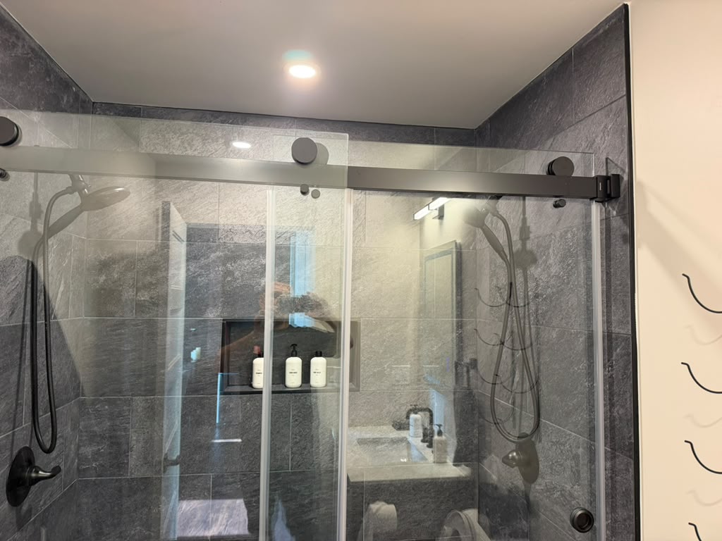 Completed bathroom remodel with custom walk-in shower and glass enclosure by Ronie Construction in Massachusetts