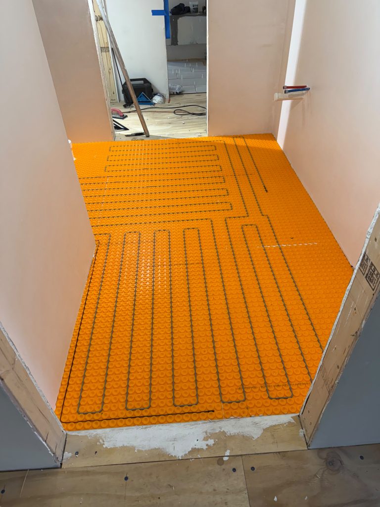 Radiant heated bathroom floor installation during a Ronie Construction remodel in Massachusetts